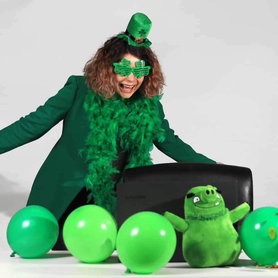 Woman in green St. Patrick's day costume before laptop
