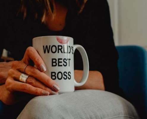 Woman holding a "World best Boss" mug.